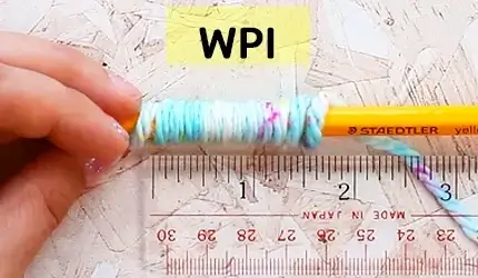yarn wrapped around a pencil to demonstrate wraps per inch